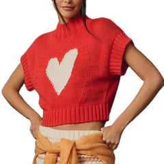 Red knitted vest with a white heart design worn by a person on a white background