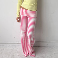 Person wearing pink and white striped pants with a yellow top against a plain background