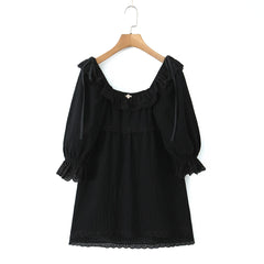 Black dress with ruffled sleeves on a wooden hanger- round ruffles neckline