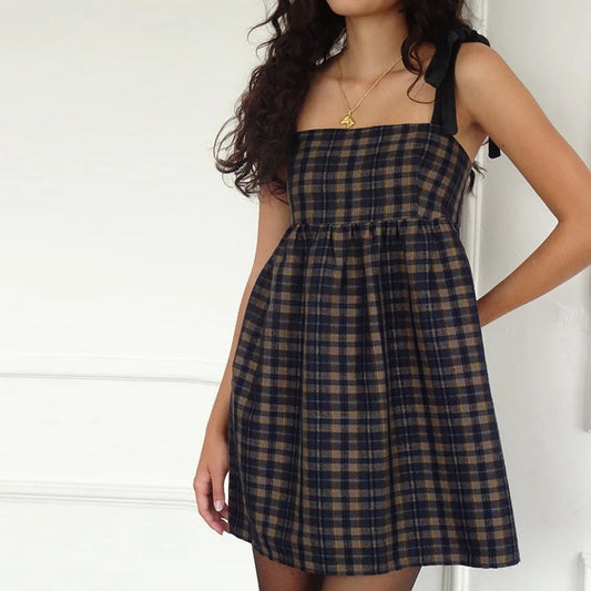 Woman wearing a plaid dress against a white background