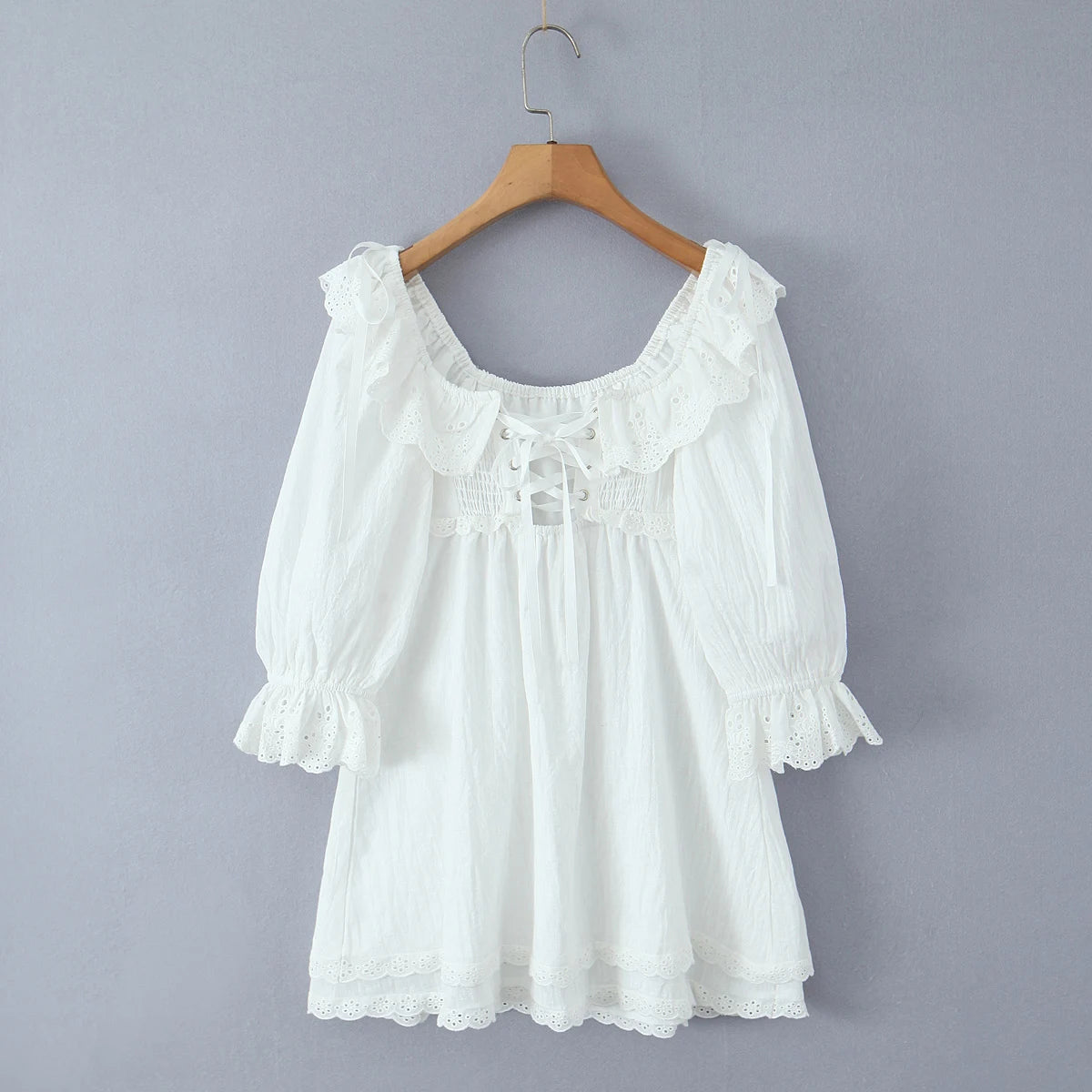 White lace dress on a wooden hanger - back view, lace details