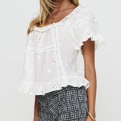 White embroidered top worn by a person - side view