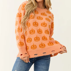 Person wearing an orange sweater with pumpkin patterns on a plain background