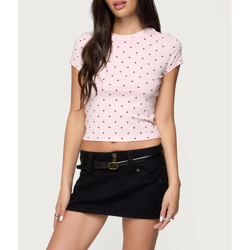 Woman wearing a pink polka dot crop top and black skirt