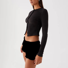 Model displaying a ribbed button long sleeve top with an O-neck and asymmetrical button detailing, showcasing its Y2K style.