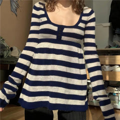 Person wearing a blue and white striped sweater in an indoor setting