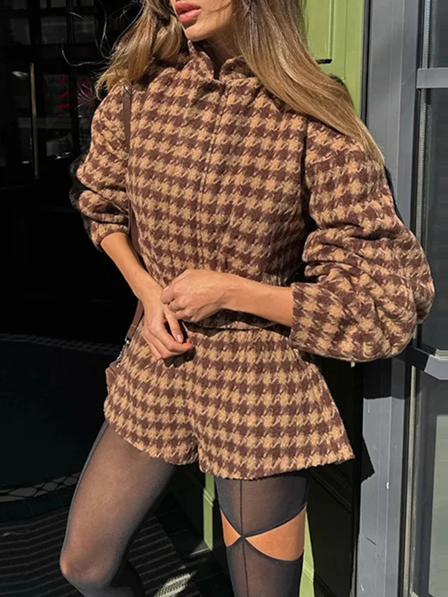 Woman wearing a brown houndstooth pattern outfit with sheer stockings.