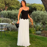 Woman in a black and white dress standing in a garden