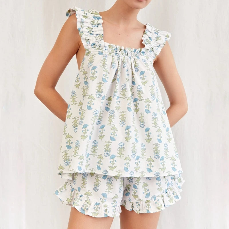 Child wearing a floral dress with ruffled sleeves on a white background