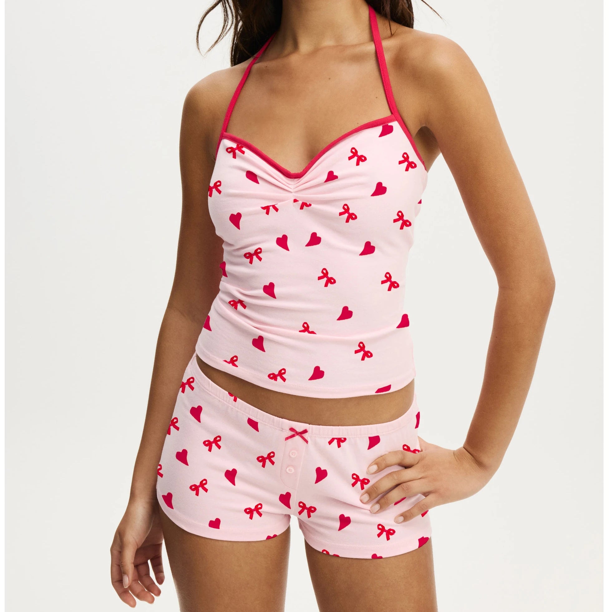 Pink pajama set with red patterns on a white background