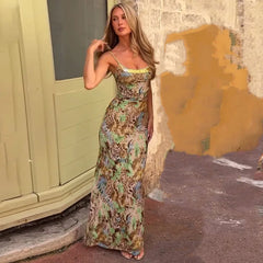 Woman in a floral dress standing against a textured wall.