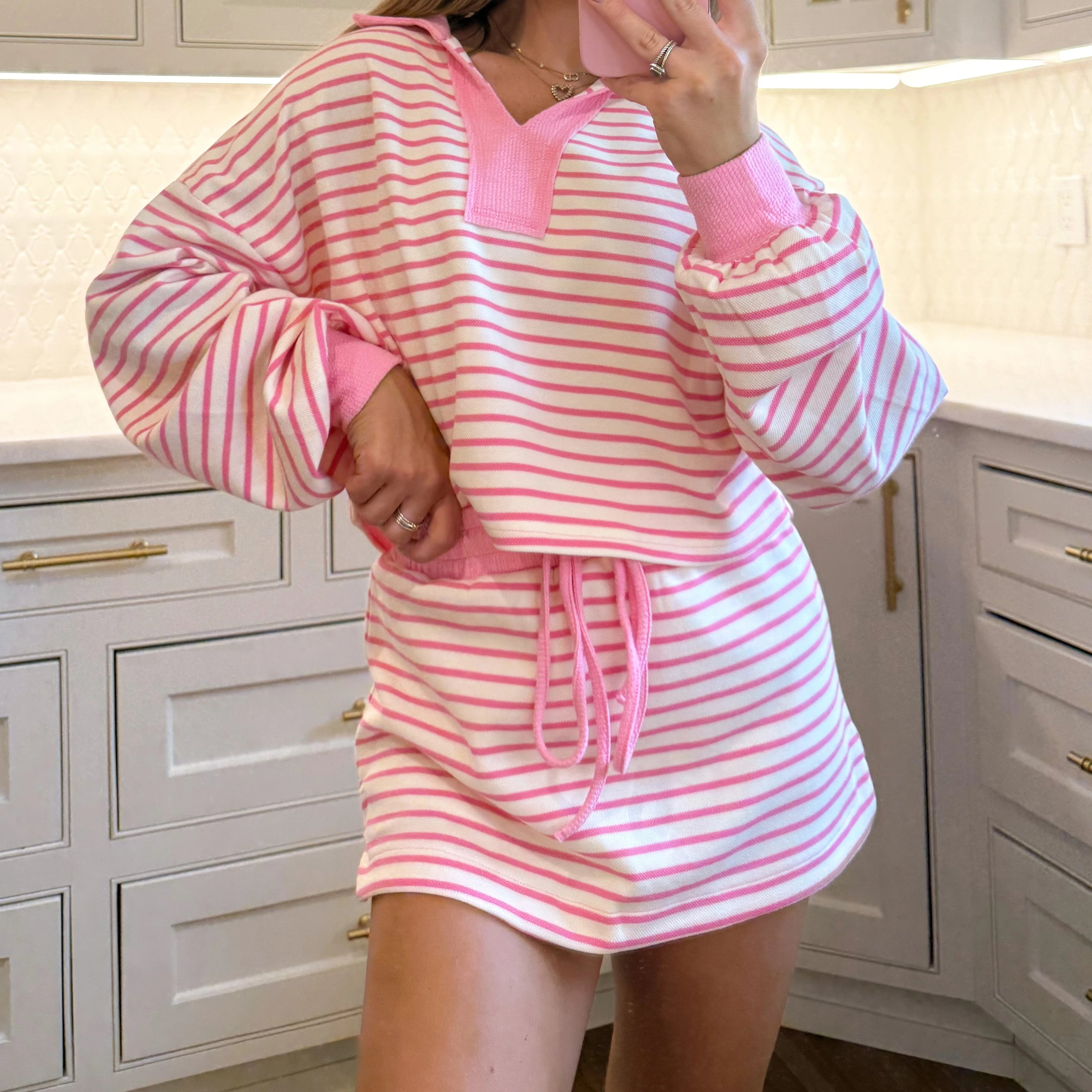 Person wearing a pink and white striped outfit in a kitchen setting