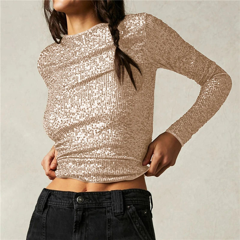 Person wearing a sparkly beige long-sleeve top against a neutral background