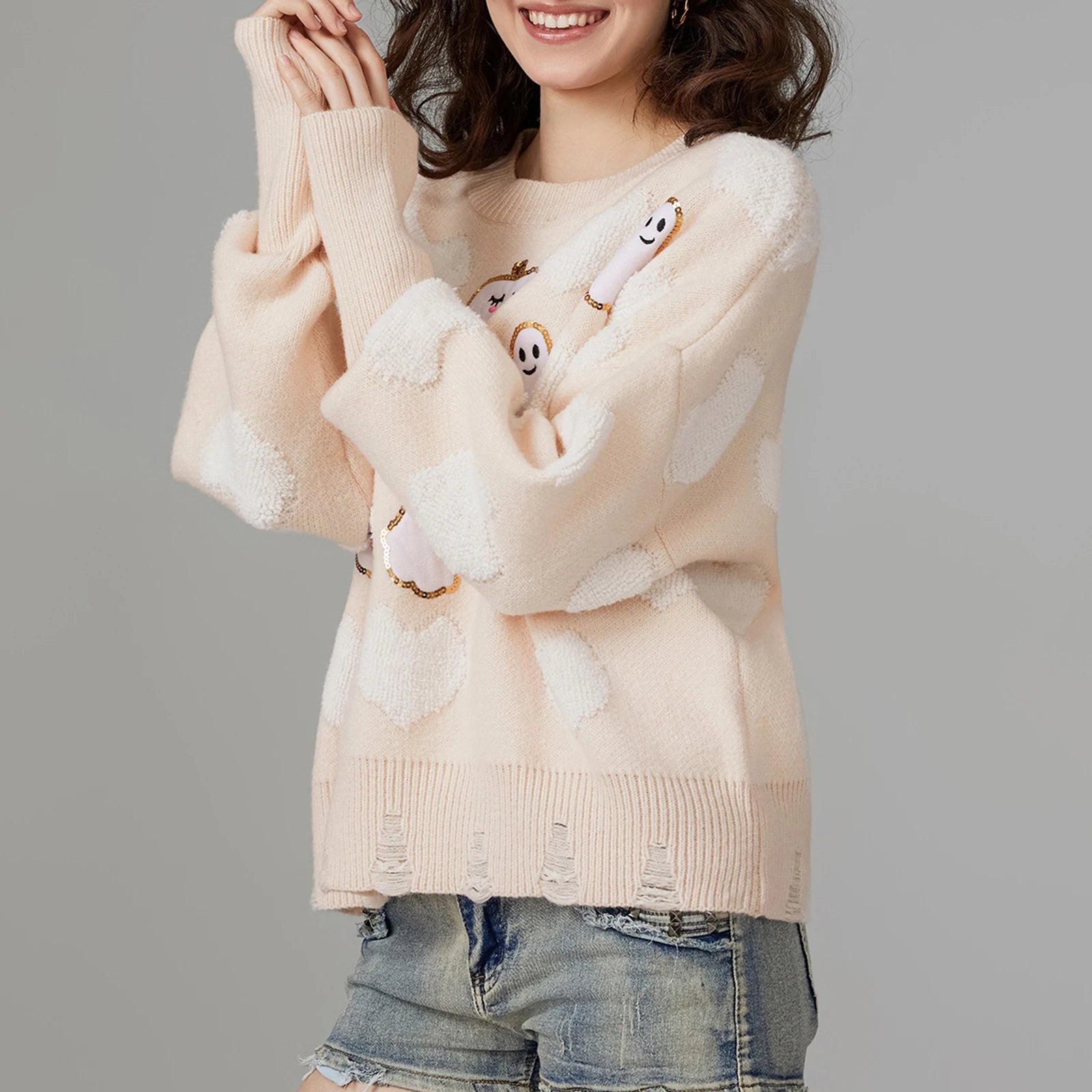 Person wearing a beige sweater with cartoon character designs on a gray background