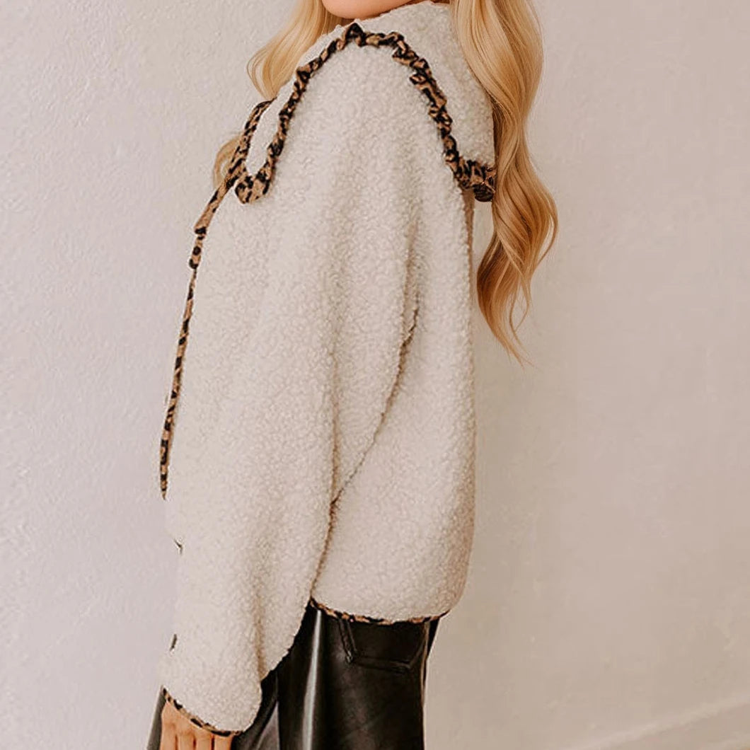 Person wearing a white textured sweater with leopard print straps