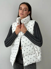Woman wearing a white quilted vest with black accents on a gray background