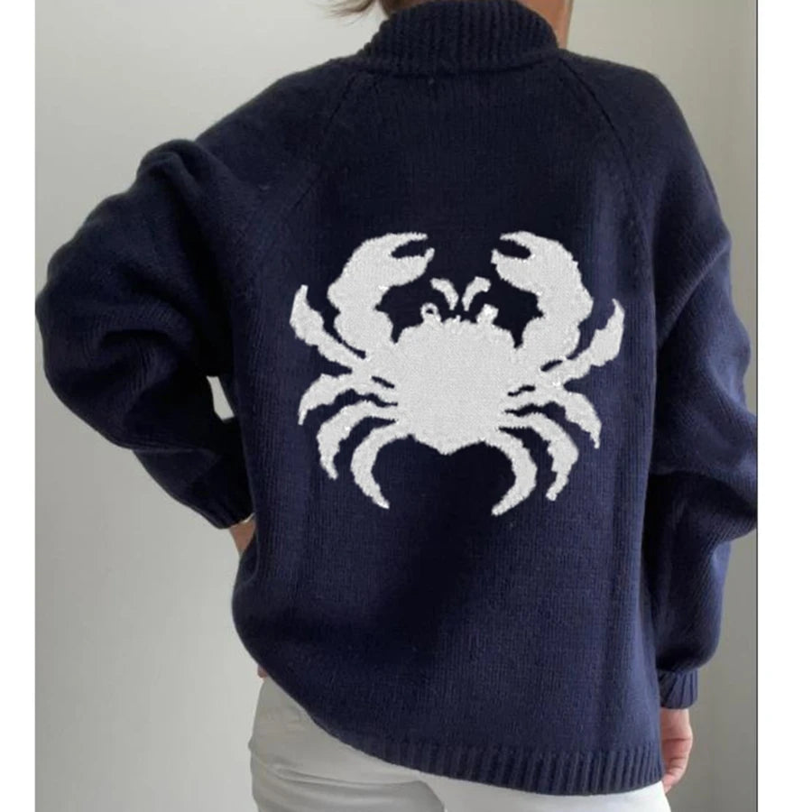 Navy blue sweater with a white crab design on the back, worn by a person.
