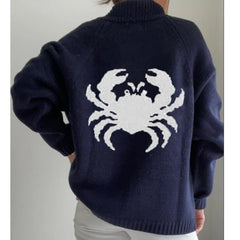 Navy blue sweater with a white crab design on the back, worn by a person.