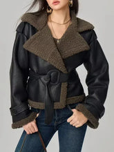 Black leather jacket with brown fur collar and cuffs worn by a model on a gray background