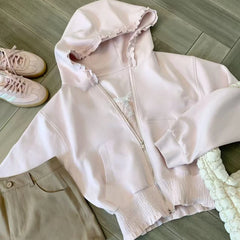 Pink hoodie with lace details on a wooden floor