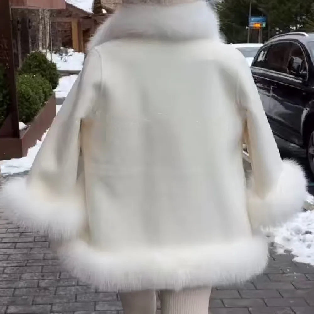 Person wearing a white fur coat in an urban setting with snow on the ground.