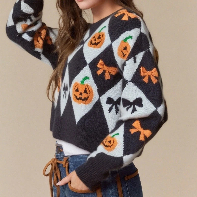 Person wearing a Halloween-themed sweater with pumpkins and bows