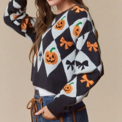 Person wearing a Halloween-themed sweater with pumpkins and bows