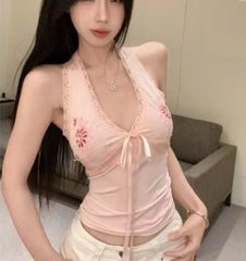 Woman wearing a pink lace top in an indoor setting