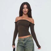 Woman wearing a brown off-shoulder top and jeans on a white background