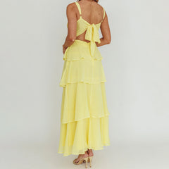 Yellow dress with a bow detail on a plain background