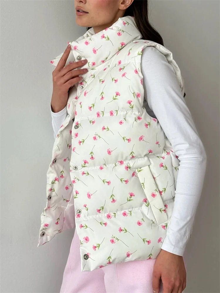 Person wearing a floral patterned puffer vest over a white shirt on a plain background