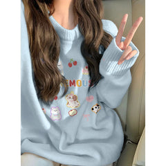 Person wearing a light blue sweater with cartoon designs, sitting in a vehicle.