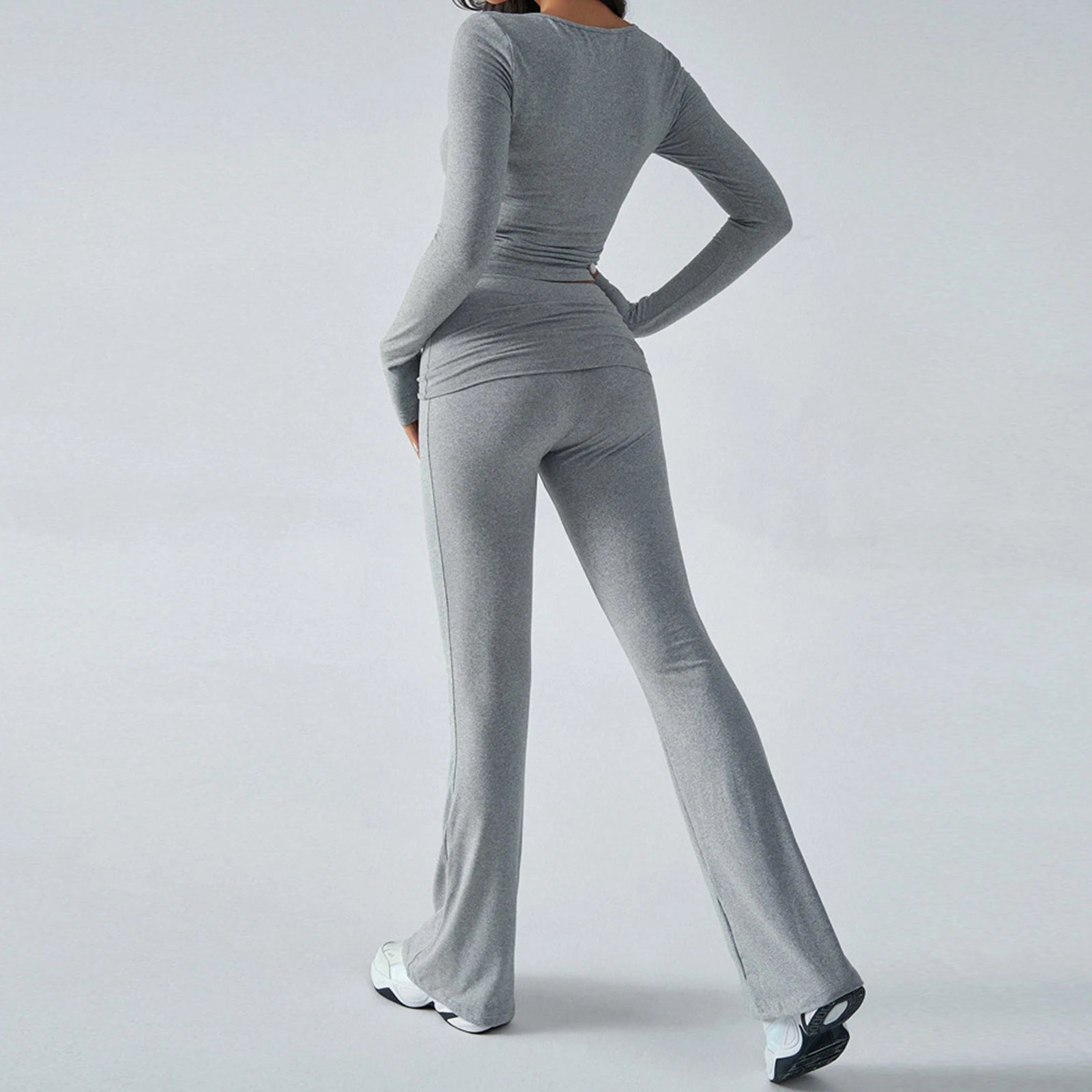 Person wearing a gray outfit with wide-leg pants on a light gray background