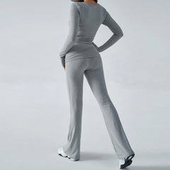 Person wearing a gray outfit with wide-leg pants on a light gray background