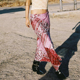 Person wearing a patterned skirt standing on a road