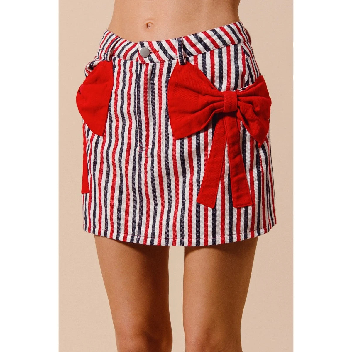 Red, white, and blue striped skirt with a large red bow on a beige background