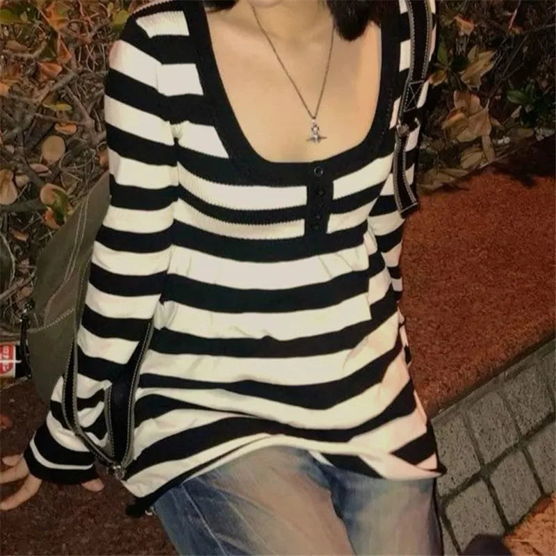 Person wearing a black and white striped shirt with a blurred background
