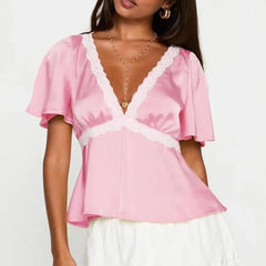 Model displaying a short lace trim flare short sleeve top with a V-neck.