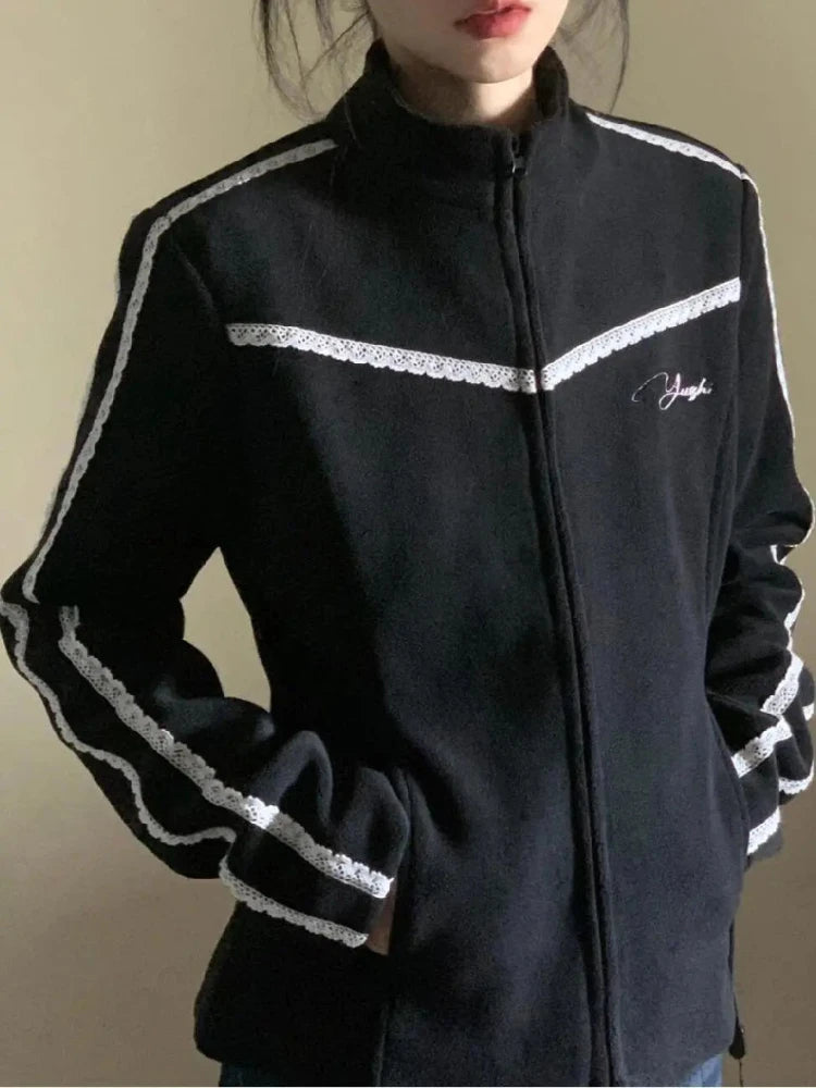 Black jacket with white accents worn by a person against a neutral background