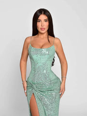 Woman wearing a sparkly green dress on a plain background
