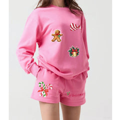 Pink Christmas-themed pajama set with gingerbread man, candy cane, and bell designs