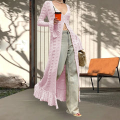 Person wearing a long pink knitted cardigan outdoors