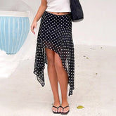 Person wearing a black polka dot skirt on a white background
