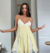 Woman wearing a light yellow dress with lace details in an indoor setting