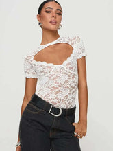 Woman wearing a white lace top with cut-out design and black pants