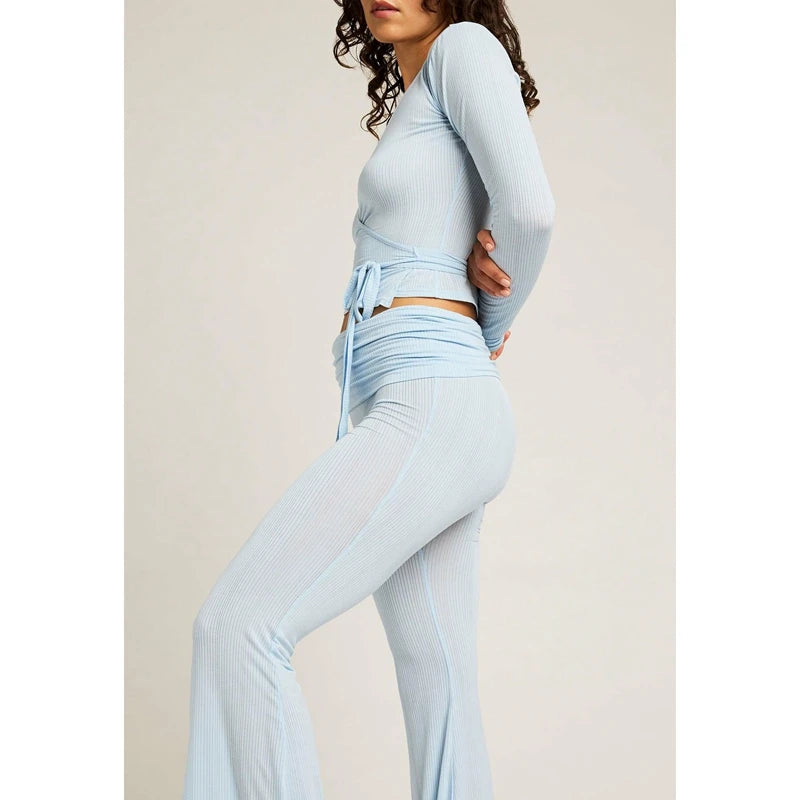 Woman wearing a light blue athletic outfit on a plain background