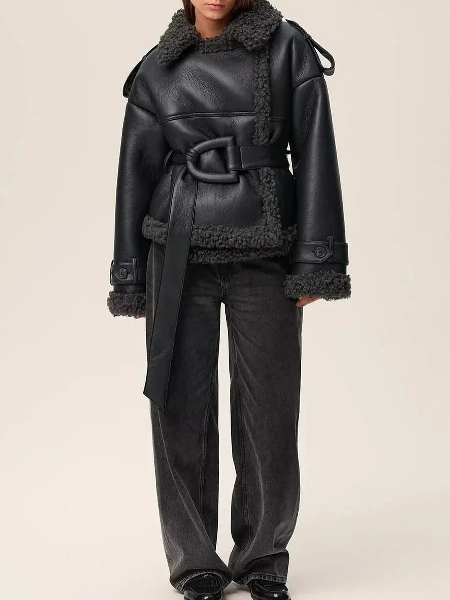 Black leather coat with shearling trim worn by a model on a beige background