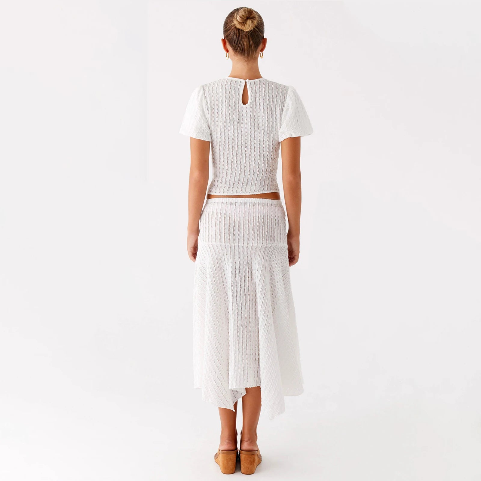 Woman wearing a white knit outfit- back