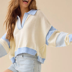 Woman wearing a cream sweater with blue accents on a beige background