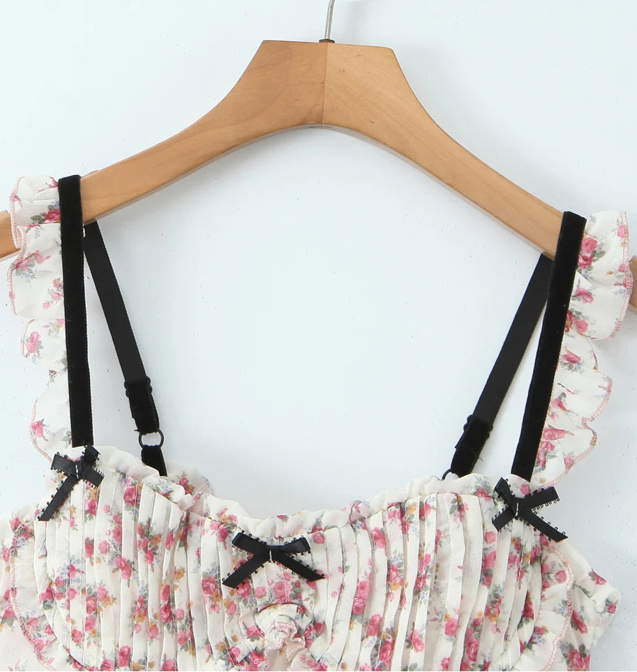Floral top with black straps on a wooden hanger- close-up